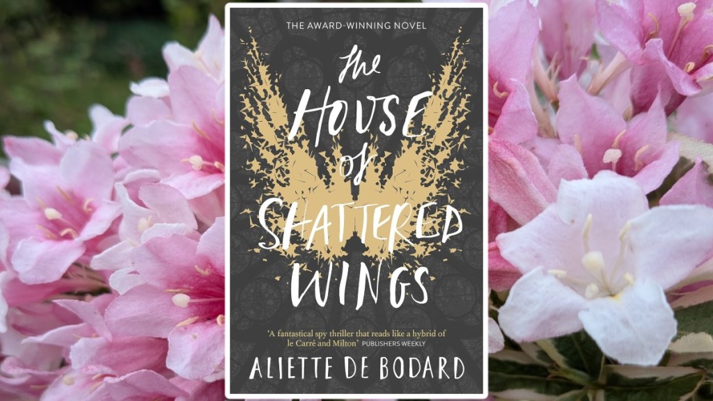 House of Shattered Wings Book Cover on a background of pink weigelia