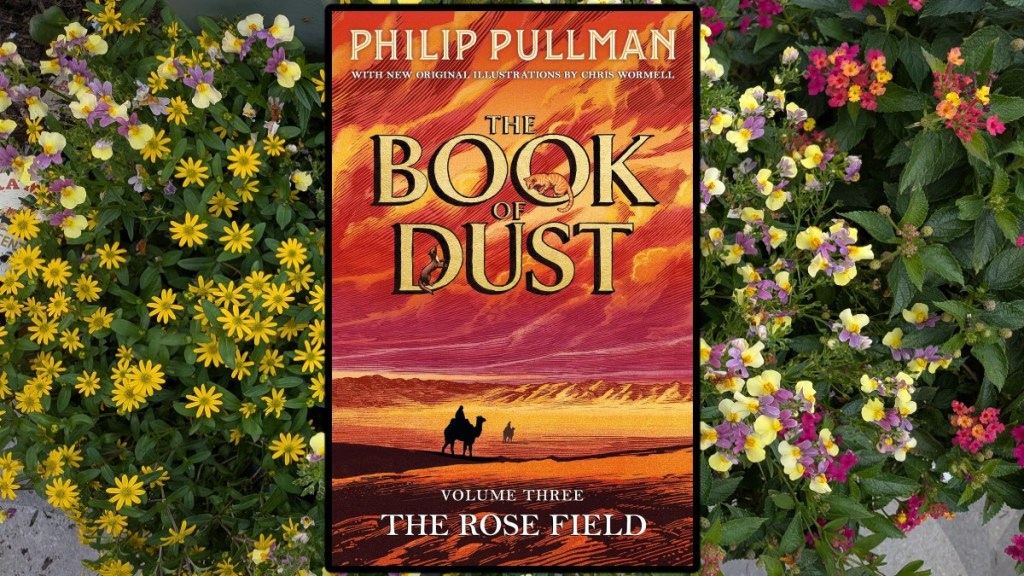 Book of dust book cover over yellow flowers.